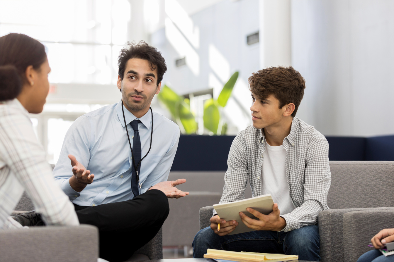 High school counselor talks with students